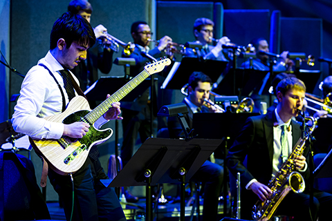 A guitarist plays with a band during a performance at the University of Miami